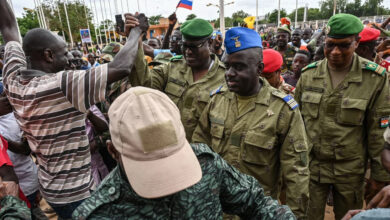 Niger's National Council for the Safeguard of the Homeland Colonel-Major Amadou Abdramane, center, is greeted by supporters as he arrives at the Stade General Seyni Kountche in Niamey, Niger