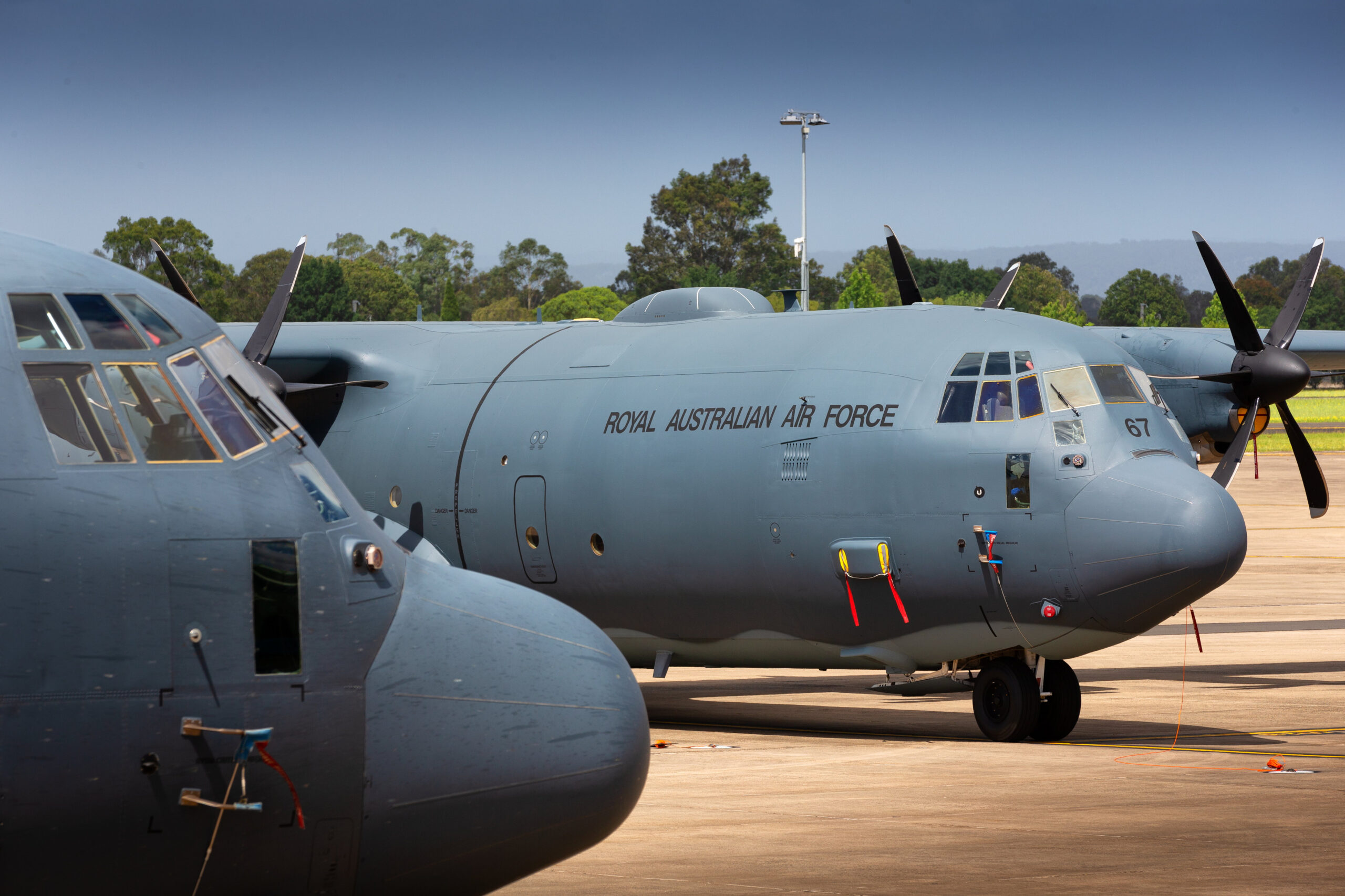 No. 37 Squadron C-130J Hercules A97-448 and A97-467 on the RAAF Base Richmond flightline. Both aircraft have been fitted with Ka-Band Satellite Communications antennas. *** Local Caption *** A second C-130J Hercules has been fitted with a Ka-Band Satellite Communications (SATCOM) antenna, providing aircrew and embarked personnel with high-speed data connectivity whilst on missions around the globe. The Ka-band SATCOM system was installed on C-130J A97-467, and follows an installation of the same system on A97-448 in 2017. Air Force plans to equip a total of six C-130Js with the SATCOM system, which can support live-streaming of high-definition video, in-flight mission planning, and coordination with headquarters and other nodes around the world.