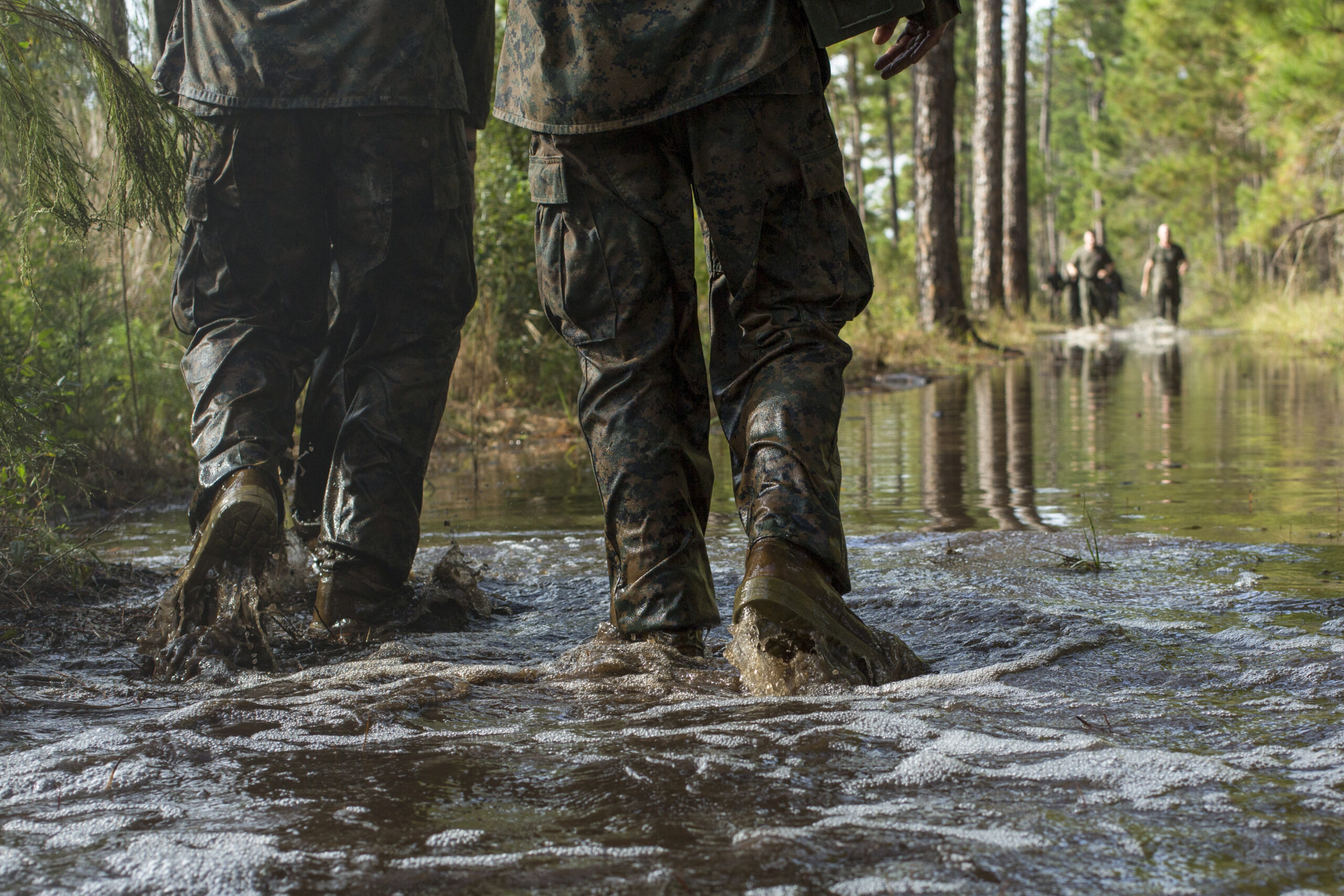 U.S. Marines with Headquarters and Service Battalion, Marine Corps Recruit Depot Parris Island, run through water during the annual Swamp Romp aboard Marine Corps Recruit Depot Parris Island, S.C., Nov. 4, 2015. The 4.6 mile Swamp Romp is a race consisting of teams of four who volunteered to run the event. (U.S. Marine Corps photo by Lance Cpl. Richard Currier/Released)