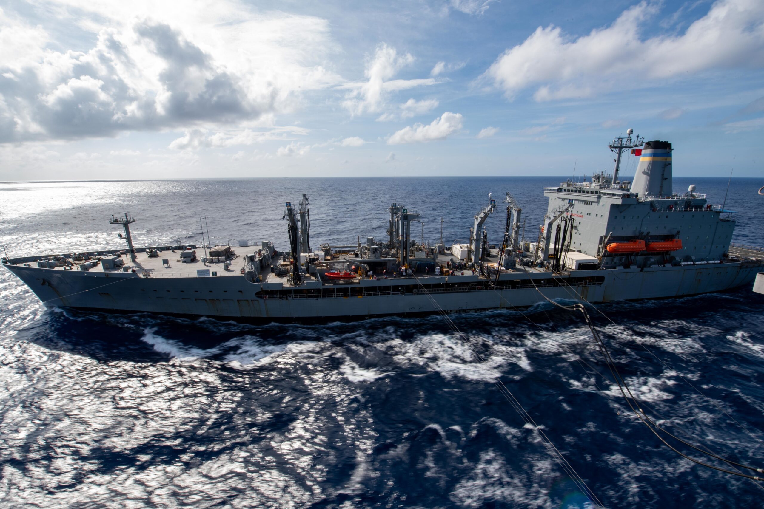 SOUTH CHINA SEA (April 24, 2020) Amphibious assault ship USS America (LHA 6) sails alongside fleet replenishment oiler USNS Pecos (T-AO 197) during a replenishment-at-sea. America, flagship of the America Expeditionary Strike Group, 31st Marine Expeditionary Unit team is operating in the U.S. 7th Fleet area of operations to enhance interoperability with allies and partners and serve as a ready response force to defend peace and stability in the Indo-Pacific region. (U.S. Navy photo by Mass Communication Specialist 3rd Class Jomark A. Almazan)