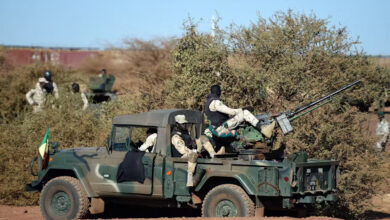 Armed and Security Forces of Mali servicemen stand guard on a military vehicle