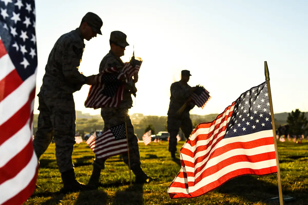 Team Hill Airmen carry flag bundles during a flag-placing detail, Utah Veterans Memorial Cemetery