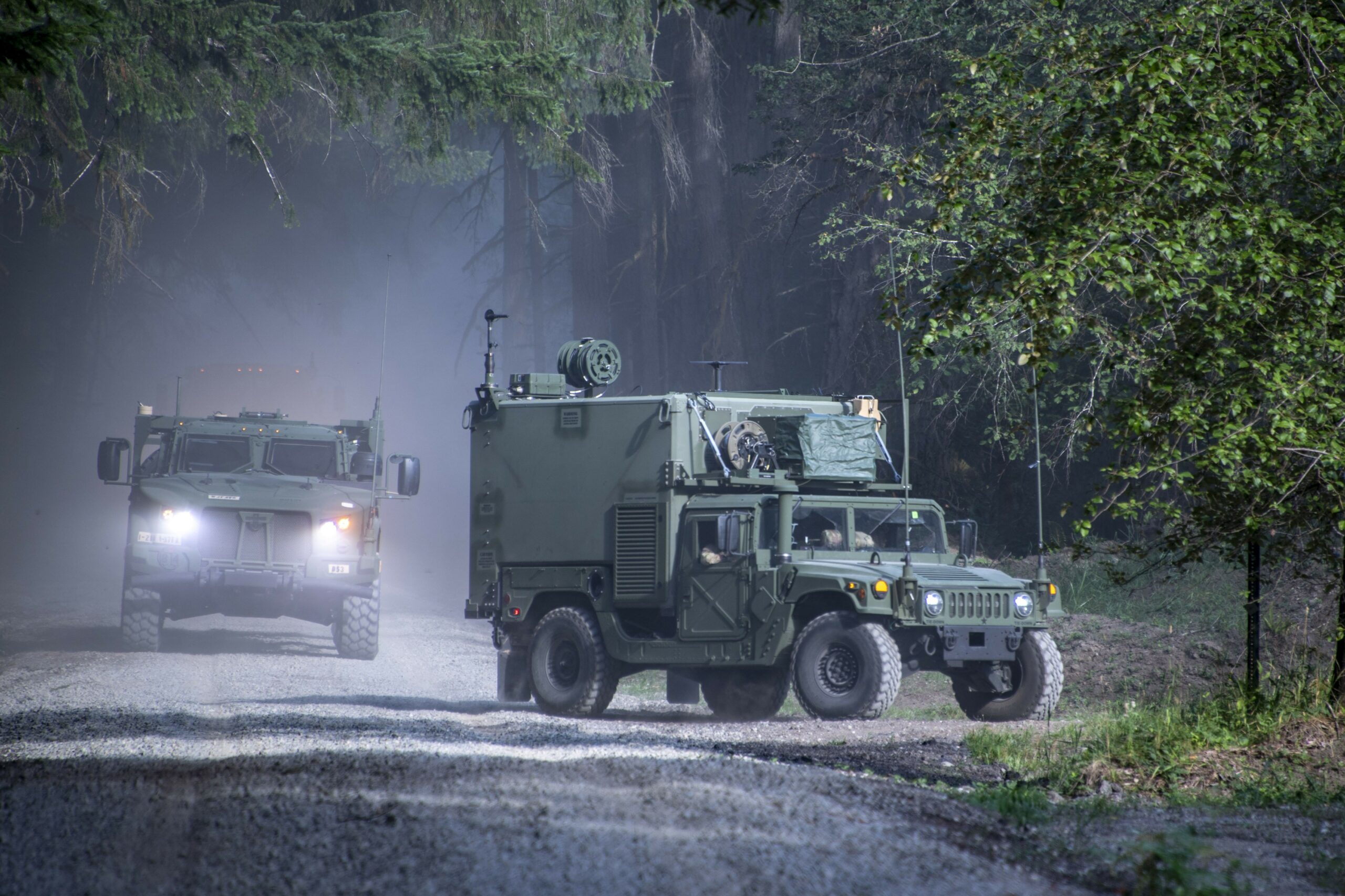 A Joint Light Tactical Vehicle (left) follows a shelter-equipped High Mobility Multi-Purpose Wheeled Vehicle of the 1st Stryker Brigade Combat Team “Ghost,” 2nd Infantry Division, into a field location at Joint Base Lewis-McChord, Washington during operational testing of the Command Post Integrated Infrastructure (CPI2). Under development in two increments, termed Increment 0 and Increment 1, the Soldiers are testing Inc. 0 of the Command Post Integrated Infrastructure (CPI2). (Tad Browning, Lead Audiovisual Production Specialist, U.S. Army Operational Test Command)