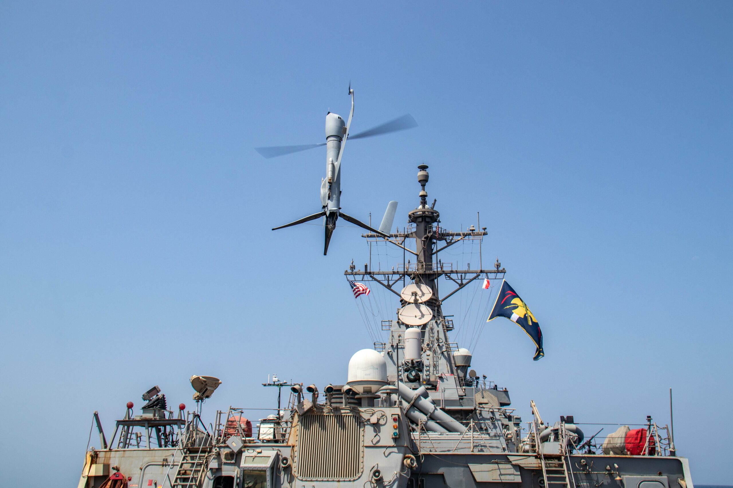231006-N-HY958-1037 GULF OF OMAN (Oct. 6, 2023) An Aerovel Flexrotor unmanned aerial vehicle launches from the deck of the Arleigh Burke-class guided-missile destroyer USS McFaul (DDG 74) in the Gulf of Oman, in an image released Oct. 6. U.S. 5th Fleet forces recently conducted an operation integrating unmanned platforms with traditionally crewed ships and aircraft to conduct enhanced maritime security operations in the waters surrounding the Arabian Peninsula. Seven task forces falling under U.S. 5th Fleet integrated 12 different unmanned platforms with manned ships for “manned-unmanned teaming” operations tracking Iranian Navy and Islamic Revolutionary Guard Corps Navy (IRGCN) ships and small boats over several days during routine patrols in and around the Strait of Hormuz. (U.S. Navy photo)