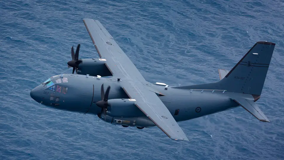 A Royal Australian Air Force C-27J Spartan aircraft is seen flying above a body of water in the background.