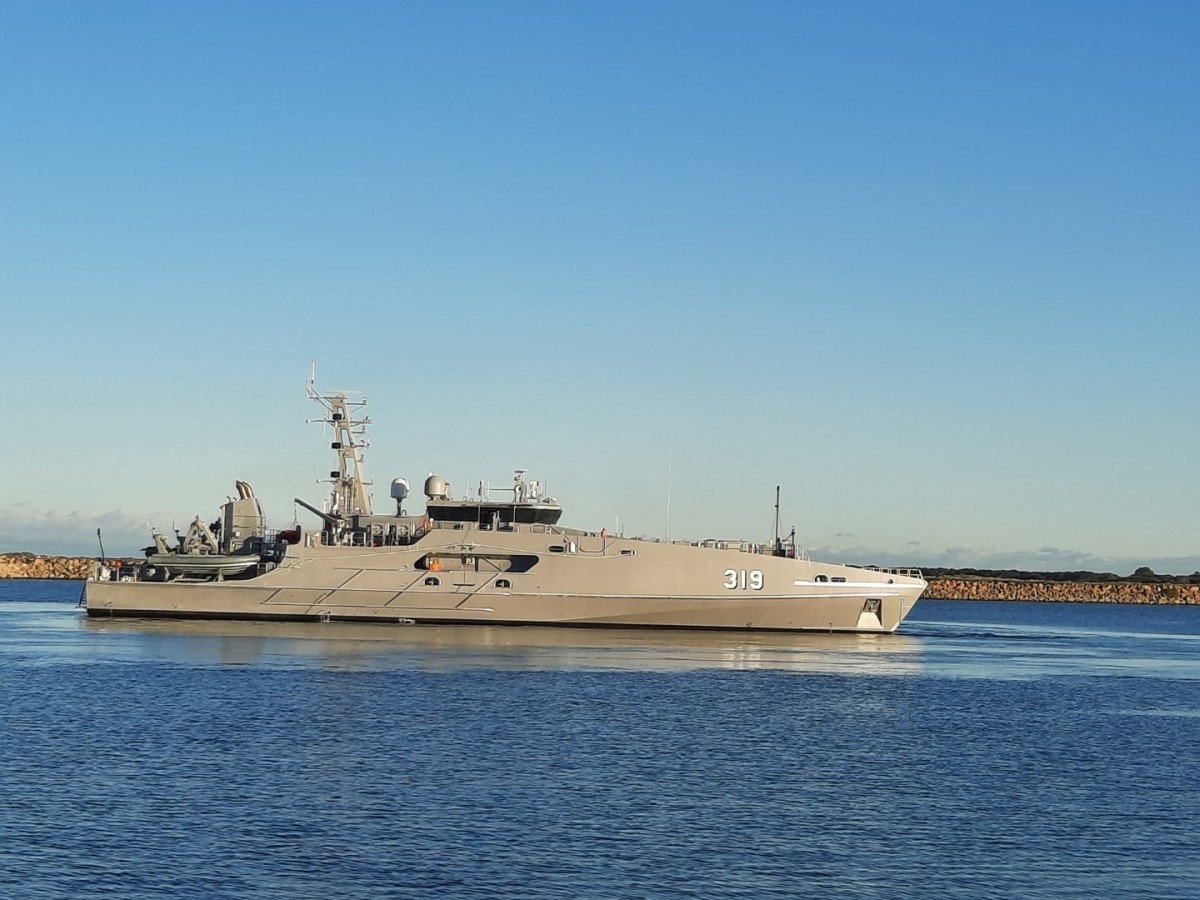 ADV Cape Pillar, Australia's newest Evolved Cape-Class Patrol Boat, is seen docked in a pier. Its hull is colored grey, with the numbers "319" painted in white on the side of the bow.