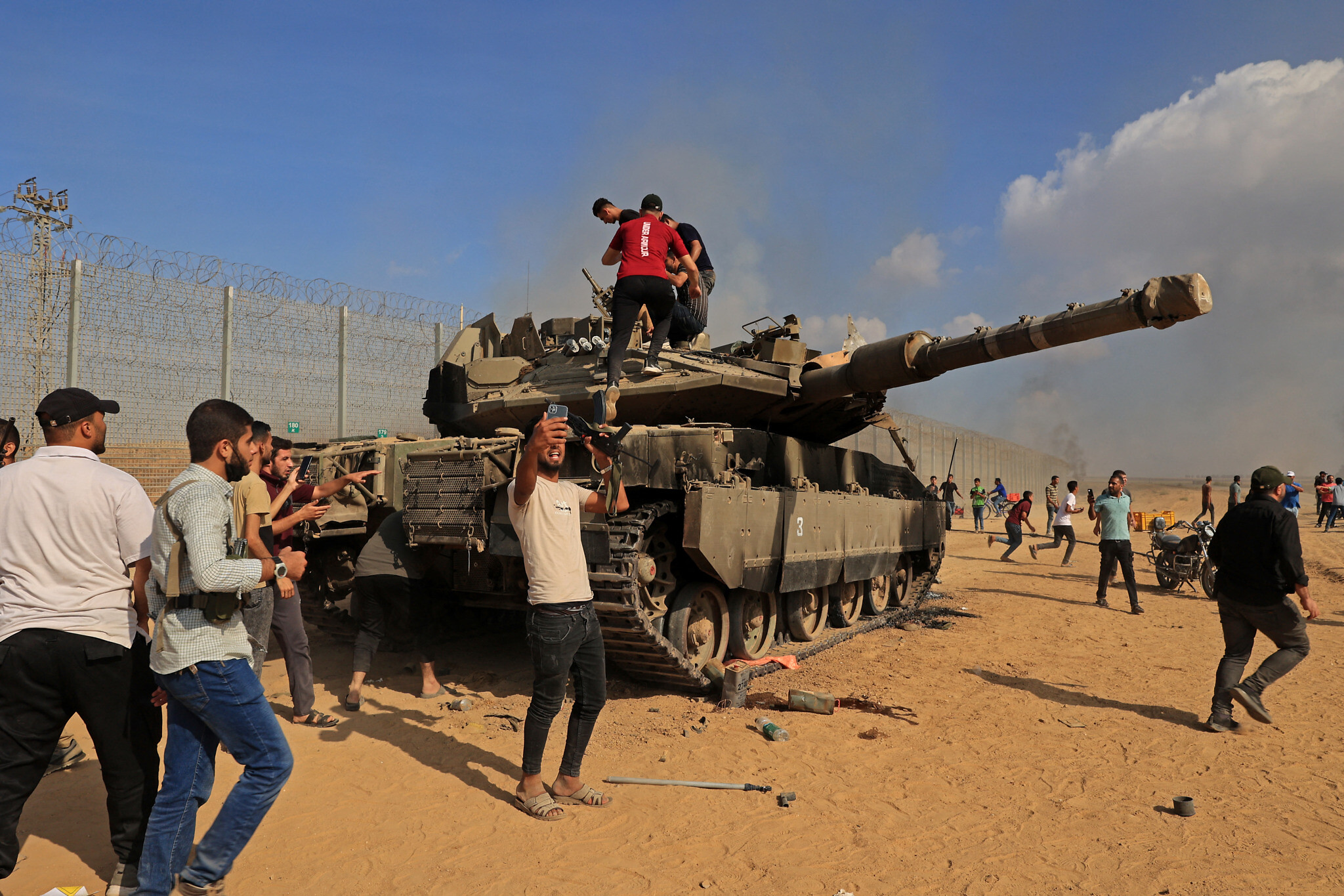 Palestinian terrorists take control of an Israeli tank after crossing the border fence with Israel from Khan Younis in the southern Gaza Strip on October 7, 2023