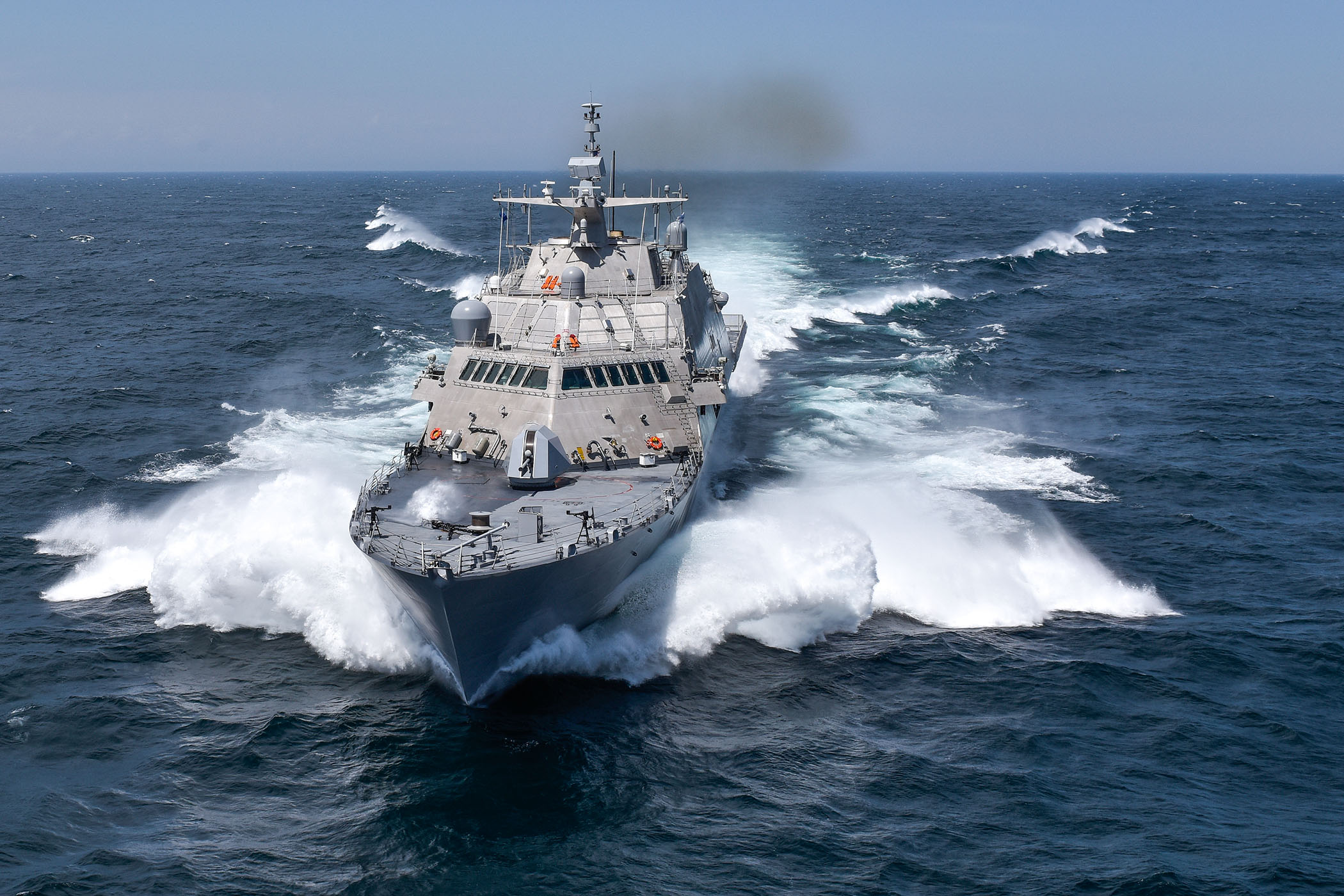 USS Detroit (LCS-7), a littoral combat ship of the US Navy, is seen sailing the waters. Sea mists are seen spraying from its sides as it moves on the water.