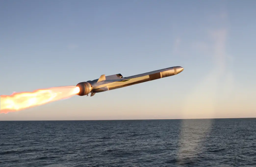 A Naval Strike Missile (NSM) flies above the water. The sun is setting in the background, albeit out of frame.