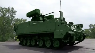 BAE Systems' prototype of the Counter-Unmanned Aircraft System (CUAS) variant of the US Army's Armored Multi-Purpose Vehicle (AMPV) is seen parked. Its hull is colored an earthy green.