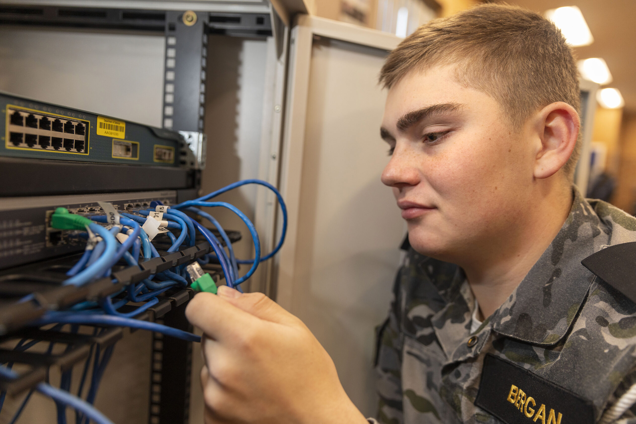 Seaman Communication Information System - Information Specialist Kyle Bergan connects a network cable to a Switch. This training in a controlled environment will allow SMN Bergan to provide live connectivity for his ship at sea, and in a real time scenarios. This is a skill that is highly relied upon by Commanding Officers at sea to ensure their ship maintains connectivity to other ships at sea and key Defence organisations ashore that provide necessary support to Naval operations *** Local Caption *** Meet some of the Navy’s newest communicators currently under training at HMAS Cerberus. Alex, Kyle & Grisadarporn all started their journeys with the Navy through the ANC, they are well on their way to careers in the Information Warfare community.Alex, a communications specialist in training, joined from TS Walrus. His professional development encompasses Satellite systems, radio systems, voice procedures, tactical manoeuvring of ships, in addition to other means of communications that are critical to Navy’s ability to remain engaged. Kyle (TS Toowoomba) and Grisadarporn (TS Henty) are training to be Information Systems specialists. Their areas of responsibility will include the management and support of Navy’s ICT at sea. They are progressing their development under the CompTIA certification framework. Collectively, these sailors will contribute to the establishment, maintenance and protection of Navy’s Information Environments against a wide range of threats including Cyber attack.