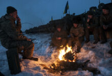 Crew members of a Ukrainian BMP-2 armored vehicle warm themselves by a fire before returning to the firing line for a night fire exercise at the International Peacekeeping and Security Center, near Yavoriv, Ukraine, on Feb. 16. (Photo by Sgt. Anthony Jones, 45th Infantry Brigade Combat Team)