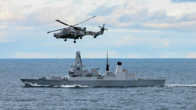 815 Wildcat fitted with Martlet missile flies above HMS Diamond.