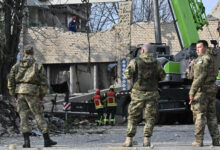 Rescuers clear debris at a partially destroyed building after an air strike in the town of Rzhyshchiv, in the Kyiv region on March 22 amid the Russian invasion of Ukraine