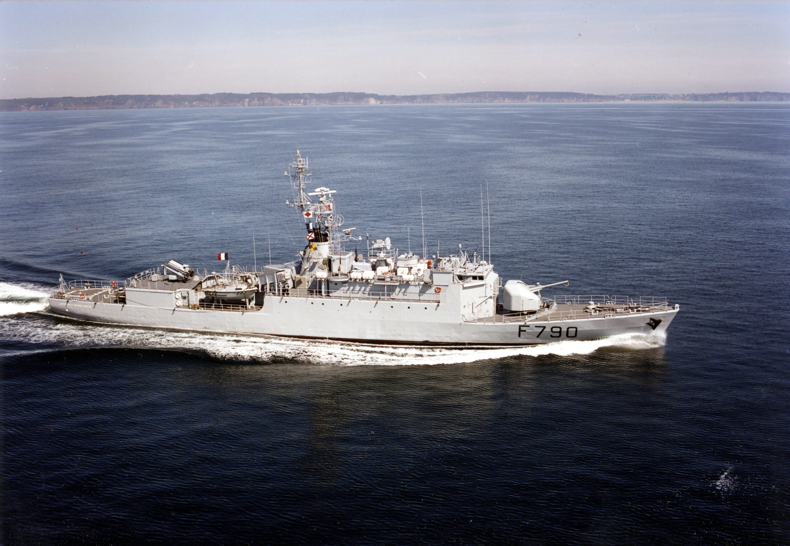 A photo of the French Navy's aviso Lieutenant de vaisseau Lavallée ship. The ship, painted light grey, is sailing in deep blue waters. A fair, cloudless sky acts as the background.