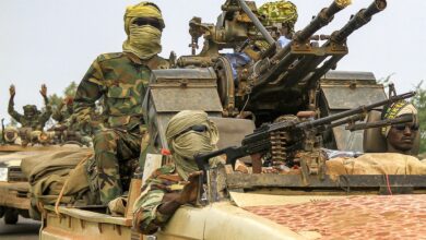 Fighters ride in a vehicle in a military convoy in Gedaref, Sudan