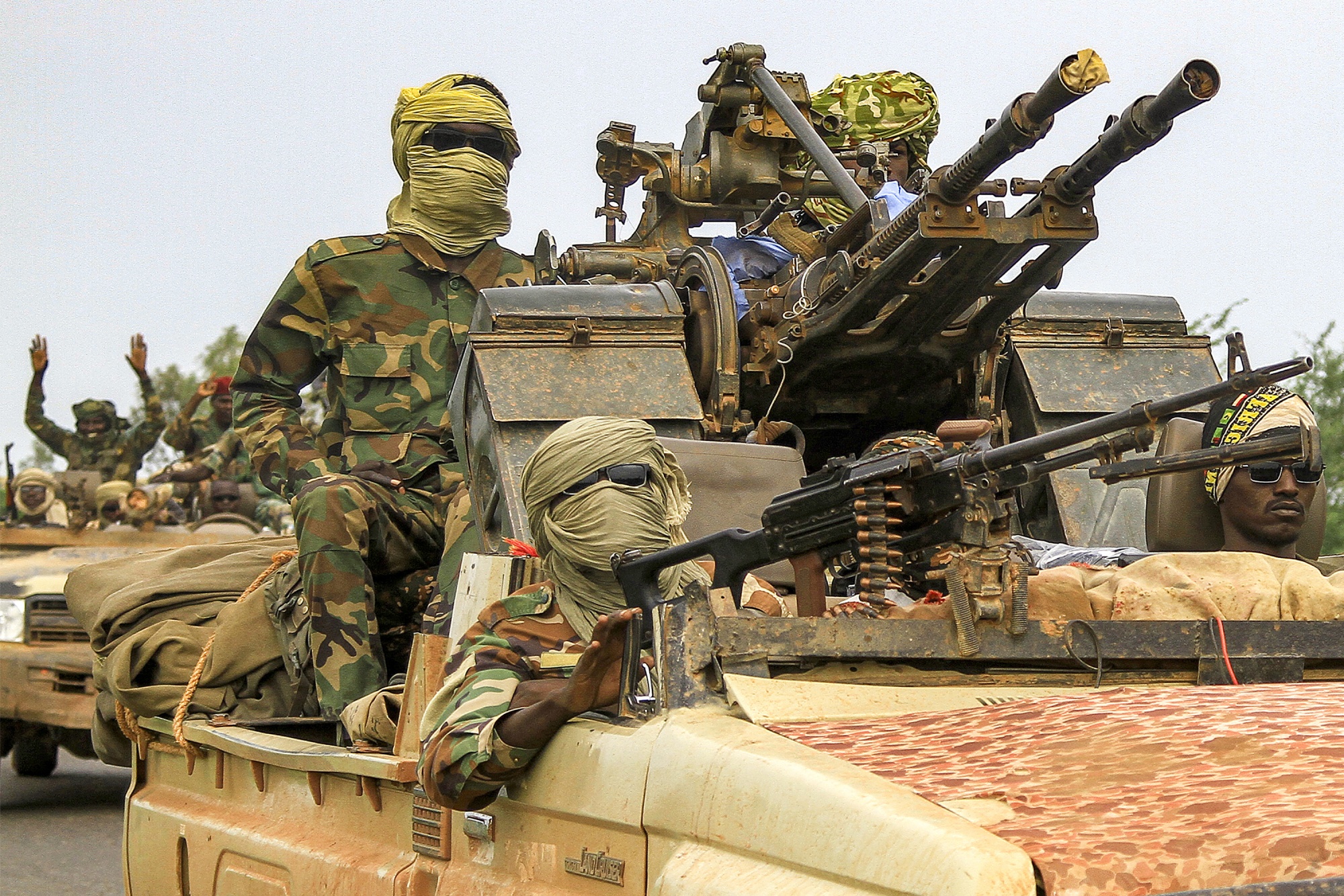 Fighters ride in a vehicle in a military convoy in Gedaref, Sudan