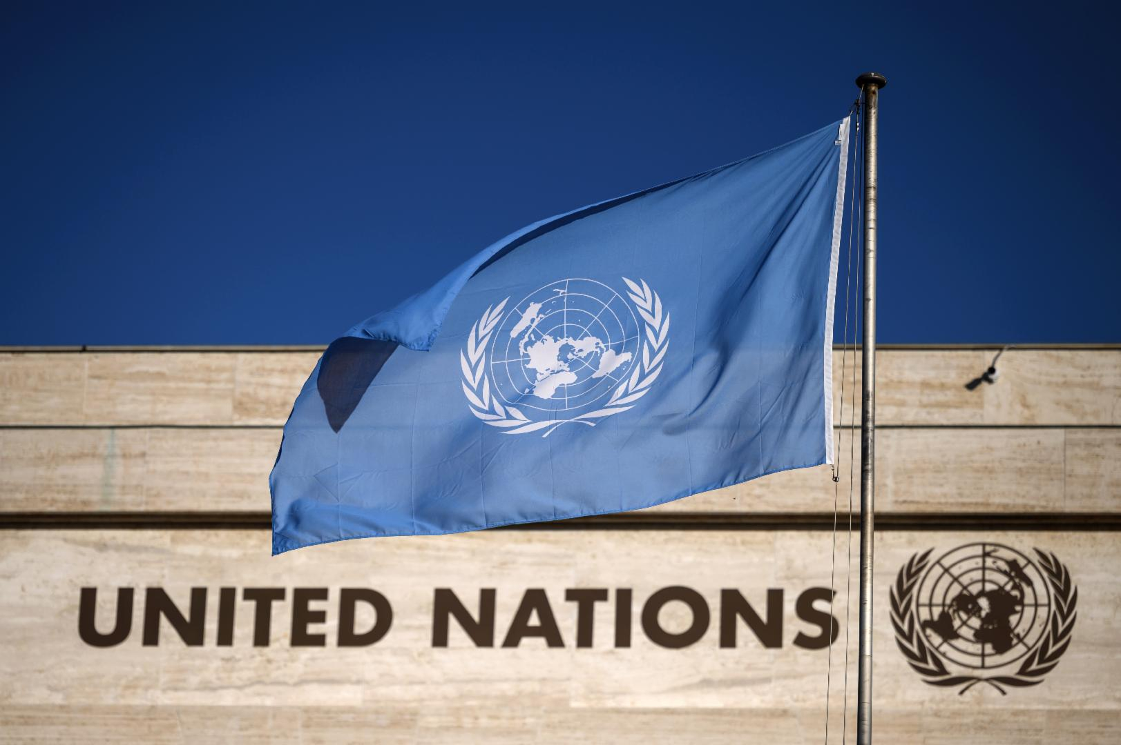 A flag flutters in wind at the main entrance of the building which houses the United Nations Offices in Geneva