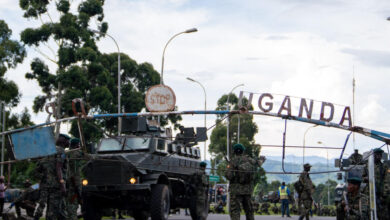 Members of the Uganda Peoples' Defence Forces (UPDF) position themselves on the Ugandan side of the border town in Bunagana, Democratic Republic of Congo, while awaiting deployment