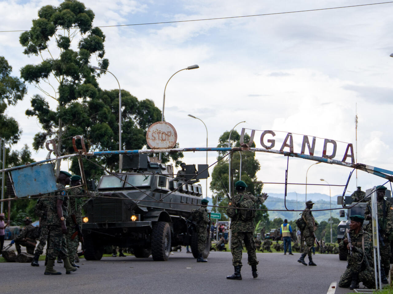 Members of the Uganda Peoples' Defence Forces (UPDF) position themselves on the Ugandan side of the border town in Bunagana, Democratic Republic of Congo, while awaiting deployment