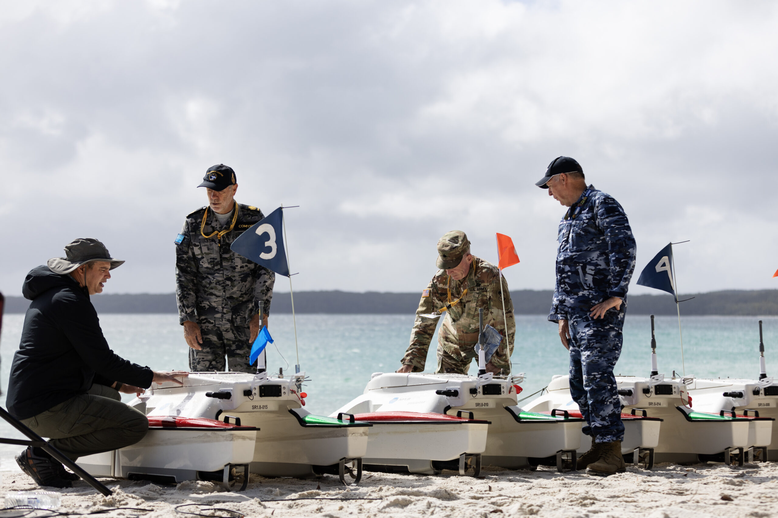 (From Left) Michael Novitzky, Warrant Officer Richard Comfort, Lieutenant Colonel Charles O'Donnell and Squadron Leader Robert Morris discuss the SWARMS Sea Robotics unmanned vehicles capability during the Technical Cooperation Program AI Strategic Challenge 2023 at HMAS Creswell, Jervis Bay Territory. *** Local Caption *** The Technical Cooperation Program (TTCP) AI Strategic Challenge (AISC) 2023 will be held at HMAS Creswell, 09-27 October 2023. Bringing together Five Eyes (FVEY) nations personnel, AISC 2023 will have a program of live experiments and demonstrations across a variety of systems, situated in a scenario representative of a full military operation. AISC 2023 is seeking to accelerate the transition of Artificial Intelligence (AI) solutions into the hands of coalition armed forces.