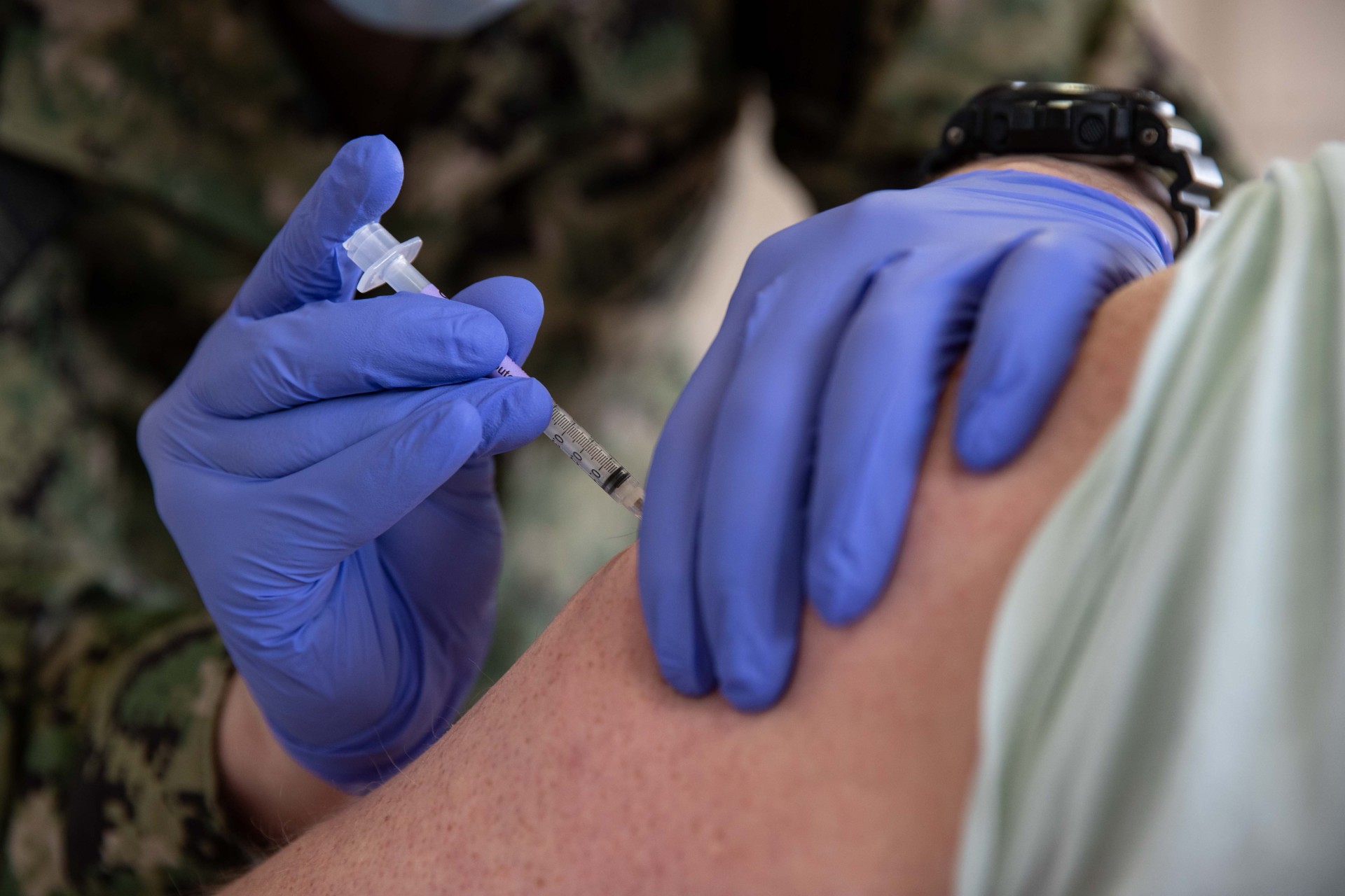 Medic administering vaccine to soldier