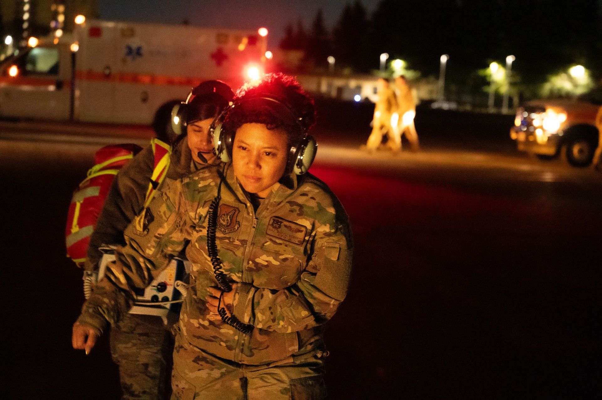 From right, U.S Air Force Maj. Ahryll Roberts, 374th Medical Group education and training flight commander, and U.S. Air Force Senior Airman Jasmin Garcia, 374th MDG medical technician, prepare to board a UH-1N Huey helicopter during a patient transport drill at Yokota Air Base, Japan, Dec. 18, 2023. Since 2019, the 459th Airlift Squadron and 374th MDG have successfully completed 14 medical transport missions, reducing patient travel time by over two hours for each leg of the journey.