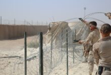 US Marine Corps combat engineers improve force protection measures by laying concertina wire at Al Asad Air Base, Iraq