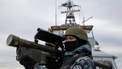 A Ukrainian serviceman holds an anti-aircraft weapon as they scan for possible air targets, onboard a boat as it patrols the northwestern part of the Black Sea