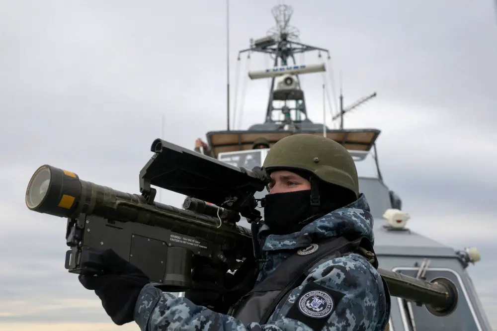 A Ukrainian serviceman holds an anti-aircraft weapon as they scan for possible air targets, onboard a boat as it patrols the northwestern part of the Black Sea