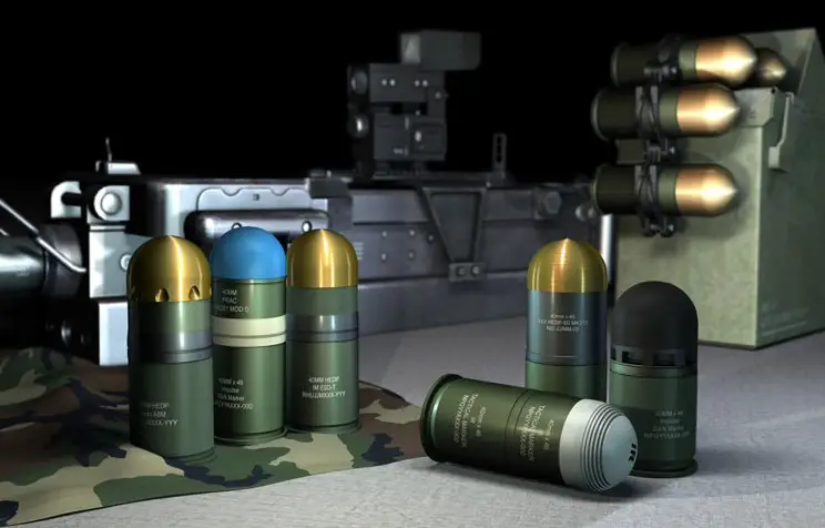 A computer-generated image displays Rheinmetall's line of 40mm x 53 ammunition. Ten ammos are seen on the image: three are standing upright on the left opposite two on the right, one is laid down in front of the latter, and four are attached to a metallic-looking box on the right side of the background. A long, gray grenade launcher is seen displayed farther in the background.