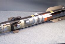 A model of a Hellfire AGM-114R2 missile is seen on display. Parts of its body is transparent, showcasing its inner parts and mechanisms.