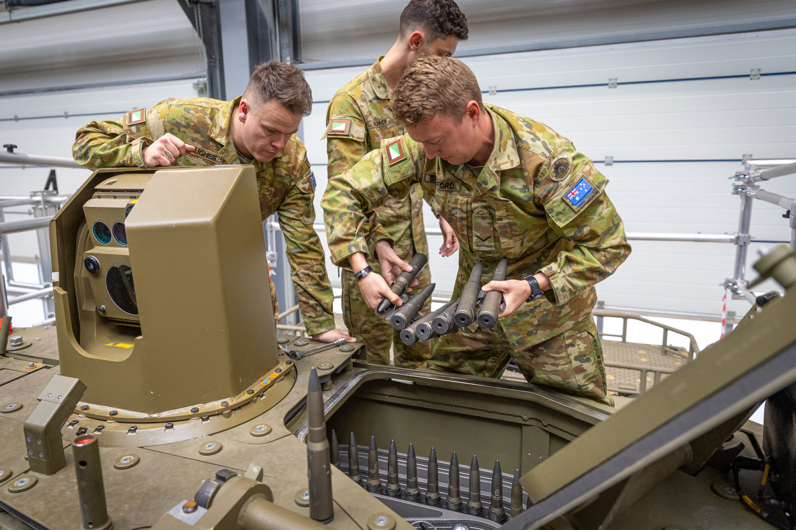 SGT Chris Hughes, LCPL Ben Crawford and TPR Liam Skinner reload the 30mm ammunition magazine on the Boxer Combat Reconnaissance Vehicle. *** Local Caption *** Testing of the Boxer Combat Reconnaissance Vehicle was recently undertaken in Germany, by members of CASG Land Domain and 2/14 LHR (QMI). Tests included firing the MK30-2 cannon and MAG58 machine gun in extreme weather conditions, as well as testing the new programmable munitions capability. Three soldiers from 2/14 LHR (QMI) were involved in testing at the Rheinmetall site in Unterluss, Germany, where the vehicle’s Lance 2.0 turret was designed and initial production has commenced. The visit included a brief on the Block II vehicle design, operation of the Combat Intelligence, Surveillance and Reconnaissance system and new weapon control systems. Development of these systems included input from 2/14 LHR soldiers, leveraging their experience with the Block I vehicles.