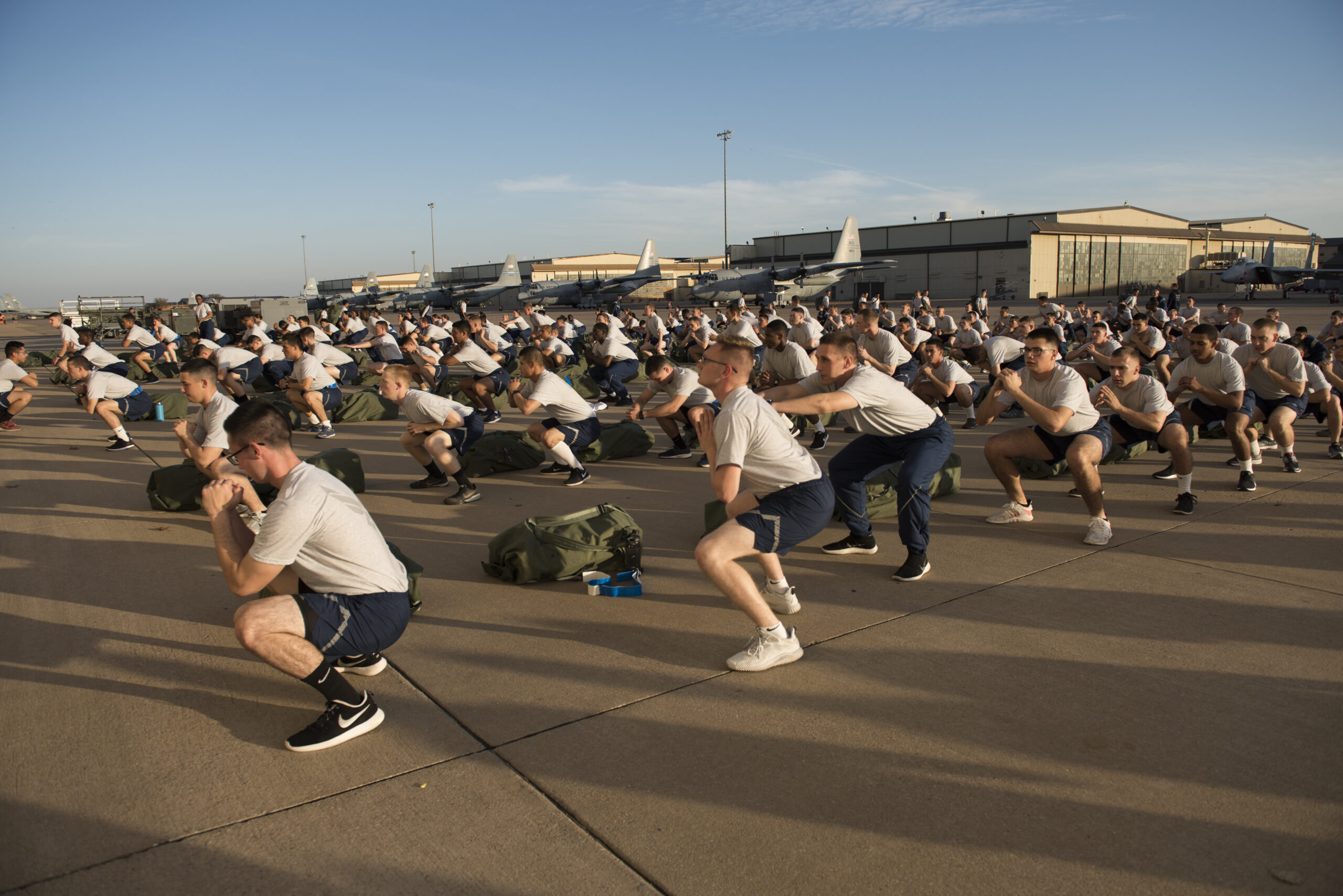 Airmen in the 363rd Training Squadron, perform squats during a physical training (PT) session at Sheppard Air Force Base, Texas, Nov. 30. PT sessions are led by military training leaders (MTL) to ensure Airmen are using proper form during their exercises. (U.S. Air Force photo by Alan R. Quevy)