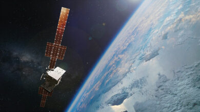 An artist's rendering of the WGS-12 satellite floating up in space. The satellite is on the left side of the image, with Earth serving as the background on the right side of the picture.