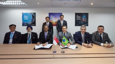 Eight officials from Embraer and ST Technologies are seen in a photo op as two of them sign the documents of the memorandum of agreement.