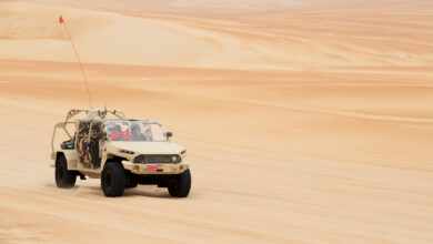 Front 3/4 view of GM Defense’s Infantry Squad Vehicle driving on sand at UAE Armed Forces Summer Trials