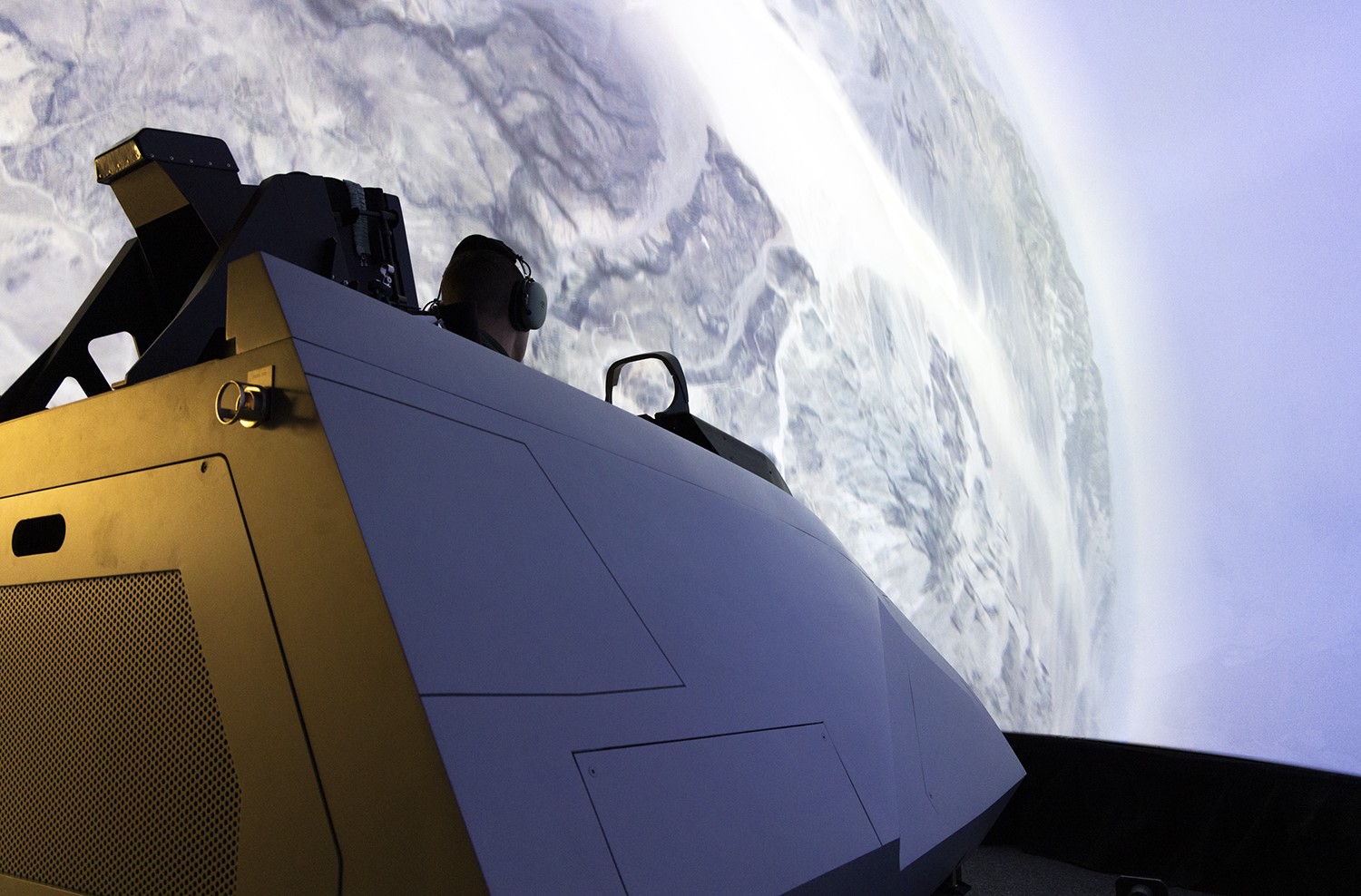 A pilot tests a U.S. Air Force F-22 Raptor cockpit simulator headed for installation in the Naval Air Warfare Center Aircraft Division’s Joint Simulation Environment. The Navy installed a division of four Raptor cockpits alongside a division of eight F-35 Lightning cockpits in its advanced tactical trainer so Navy and Air Force fighter pilots can train as a joint force starting in 2024