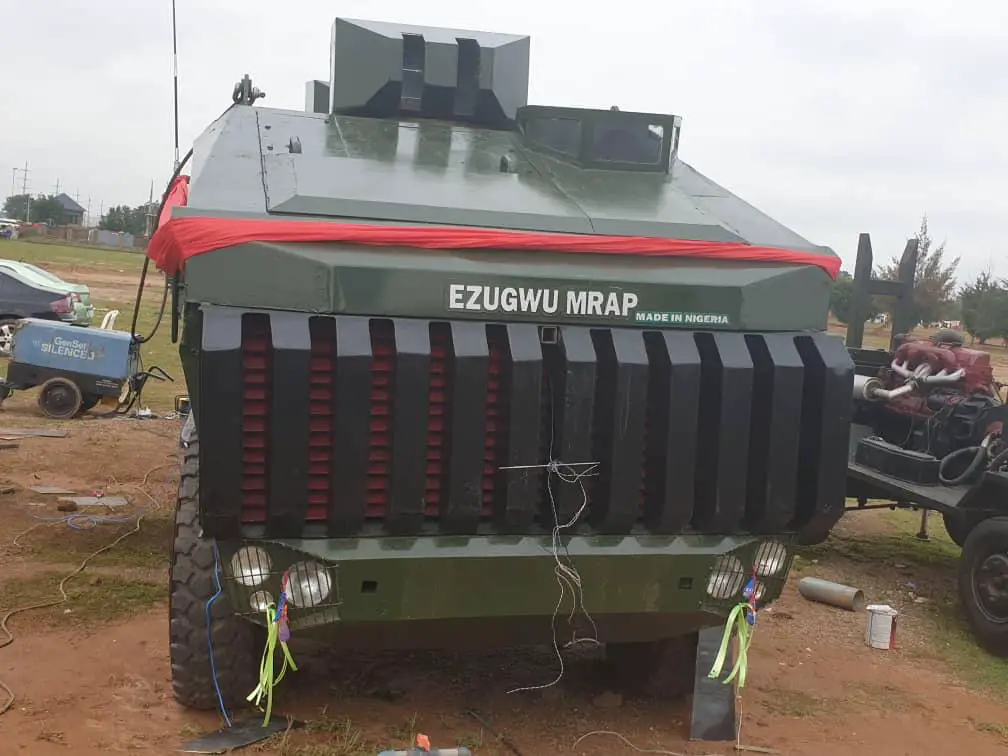 An Ezugwu Mine-Resistant Ambush Protected vehicle is seen parked. The armored vehicle is painted green, with the words "EZUGWU MRAP" painted in white in front.