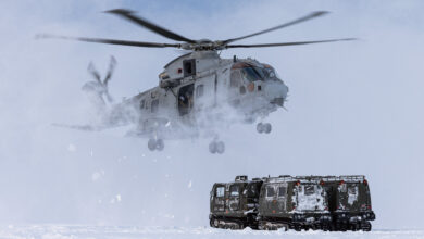 Pictured: A Merlin Mk4 of 845 NAS performs a snow landing using MAOTS BV Vehicles as reference. 845 NAS and CDO MOAT TRAIN WITH RN MEDICS IN ARCTIC ENVIRONMENT. 845 Naval Air Squadron (NAS) and the Commando Mobile Air Operation Team (Cdo MAOT) have conducted training with the Medical Squadron of Commando Logistic Regiment. The objective of the training was to teach the attached Royal Marines, Royal Navy Medical Assistants, Naval Nurses, and Medical Officers of the Forward Surgical Teams (FSTs) and as a group, known as the Commando Forward Surgical Group (CFSG) in Stage 1 Evacuation drills from the Merlin Mk4 and Arctic Casualty Loading Drills in the field. As the CFSG team were dropped off by 845 NAS, Cdo MAOT assisted by the MAOT team of the Joint Helicopter Support Squadron (JHSS) took over the training by first getting them into a ‘Arctic Huddle’ to protect themselves from the freezing downwash of the merlin as they took back off. The CFSG were then shown how to assess suitable Helicopter Landing Sites in deep snow and frozen areas. Op CLOCKWORK (Formally Exercise CLOCKWORK) has been running at Bardufoss for over 50 years and delivers Environmental Flying Qualifications, Cold Weather Survival, Tent Group Commanders and Snow and Ice driving courses to ensure that the personnel of the Joint Helicopter Command (JHC) are trained to operate in the harshest of environments.