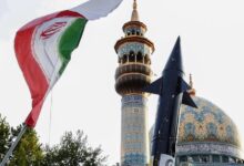 Iranians lift up a flag and the mock-up of a missile during a celebration following Iran's missiles and drones attack on Israel, on April 15 2024, at Palestine square in central Tehran