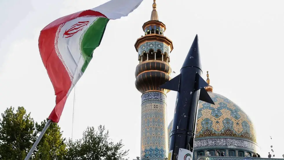 Iranians lift up a flag and the mock-up of a missile during a celebration following Iran's missiles and drones attack on Israel, on April 15 2024, at Palestine square in central Tehran