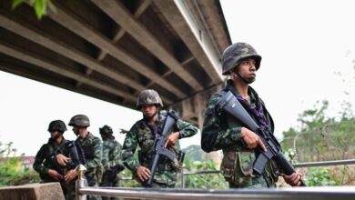 Thai military personnel stand guard overlooking the Moei river on the Thai side of the shared border with Myanmar