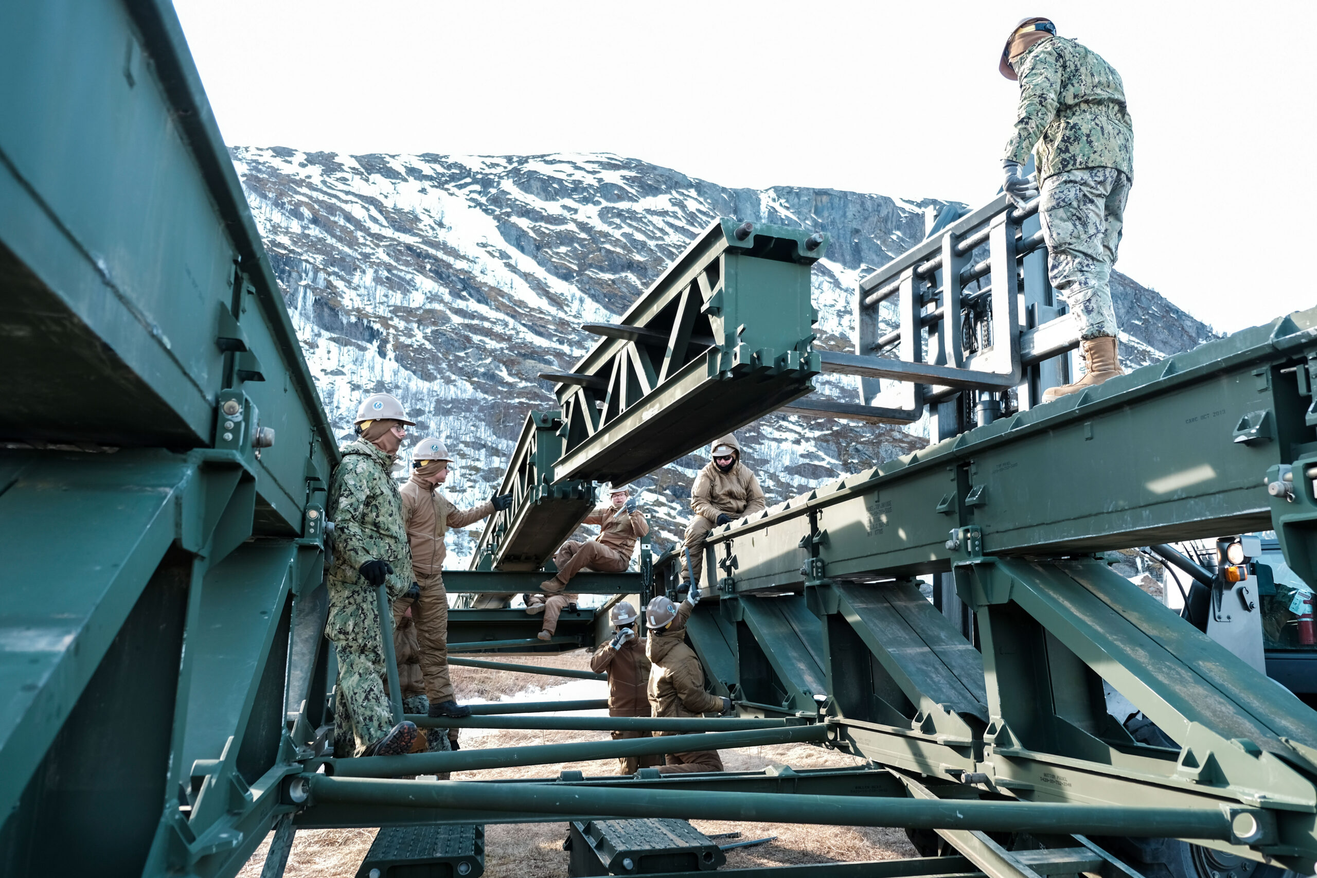 BJERKVIK, Norway (April 23, 2024) - U.S. Navy Sailors assigned to Naval Mobile Construction Battalion (NMCB) 11 assemble a medium girder bridge in support of Immediate Response 2024 in Bjerkvik, Nordland County, Norway, April 23, 2024. DEFENDER is the Dynamic Employment of Forces to Europe for NATO Deterrence and Enhanced Readiness, and is a U.S. European Command scheduled, U.S. Army Europe and Africa conducted exercise that consists of Saber Strike, Immediate Response, and Swift Response. DEFENDER 24 is linked to NATO’s Steadfast Defender exercise, and DoD’s Large Scale Global Exercise, taking place from 28 March to 31 May. DEFENDER 24 is the largest U.S. Army exercise in Europe and includes more than 17,000 U.S. and 23,000 multinational service members from more than 20 Allied and partner nations, including Croatia, Czechia, Denmark, Estonia, Finland, France, Germany, Georgia, Hungary, Italy, Latvia, Lithuania, Moldova, Netherlands, North Macedonia, Norway, Poland, Romania, Slovakia, Spain, Sweden, and the United Kingdom. (U.S. Navy photo by Builder Constructionman Laqdrick Bouldin)